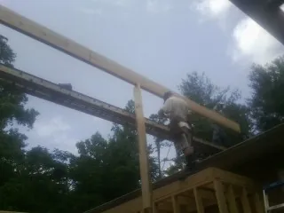 Carpenter setting a ridge beam over a new addition frame — Ice Dam Removal by Roofing Brothers in Hampstead